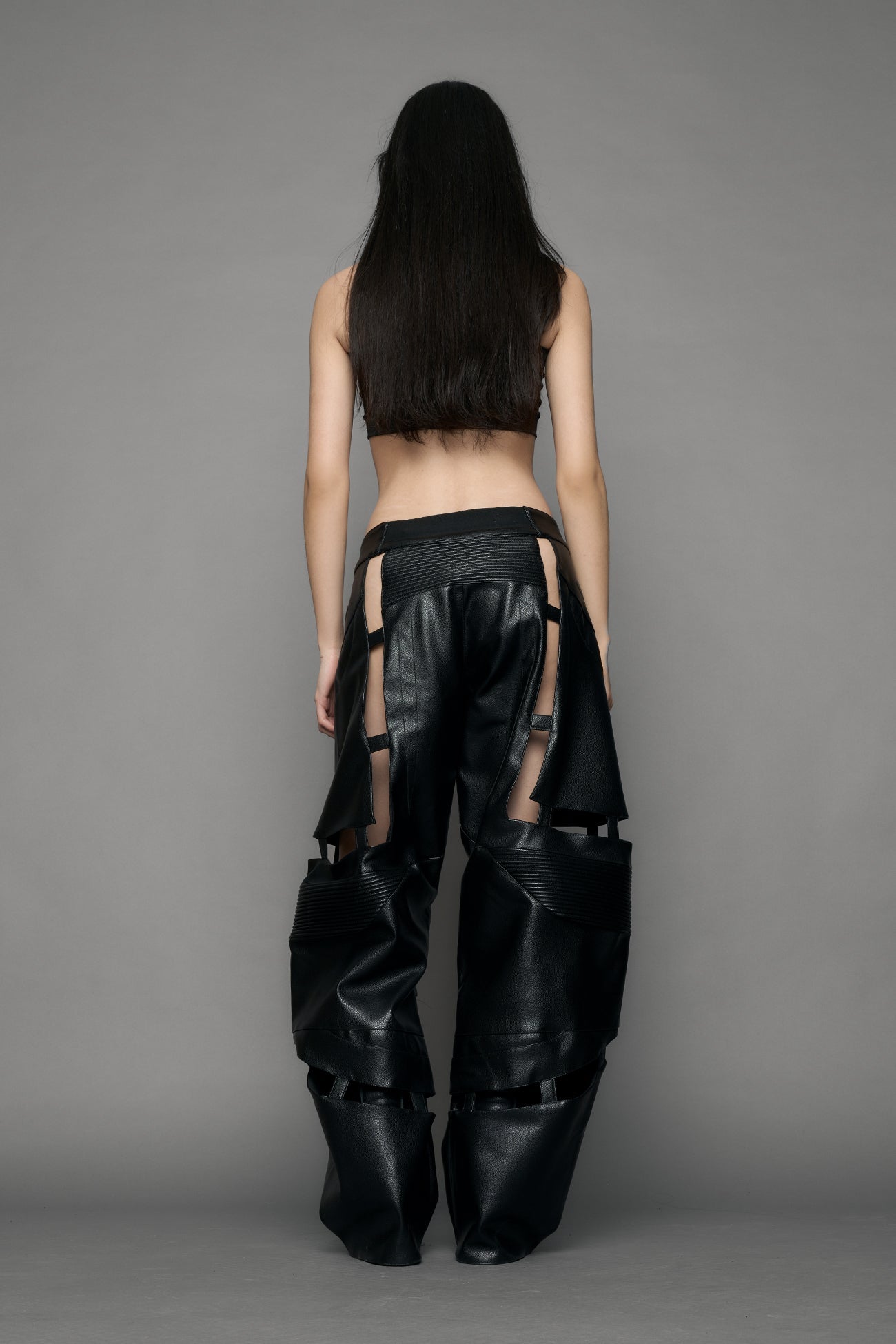 model wearing black pu leather pants with cut out details