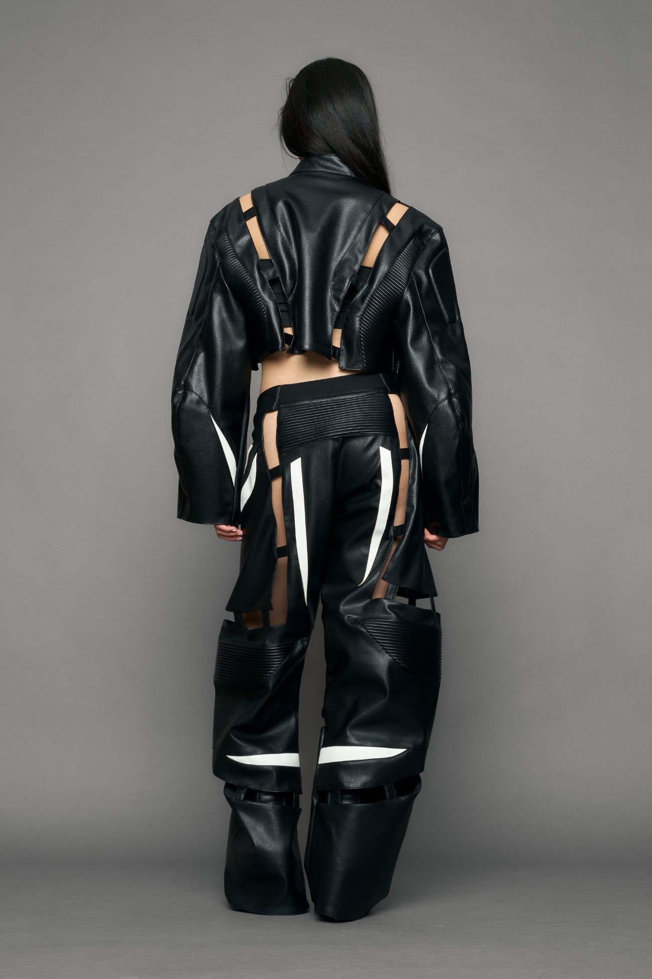 model wearing black and white pu leather pants with cut out details