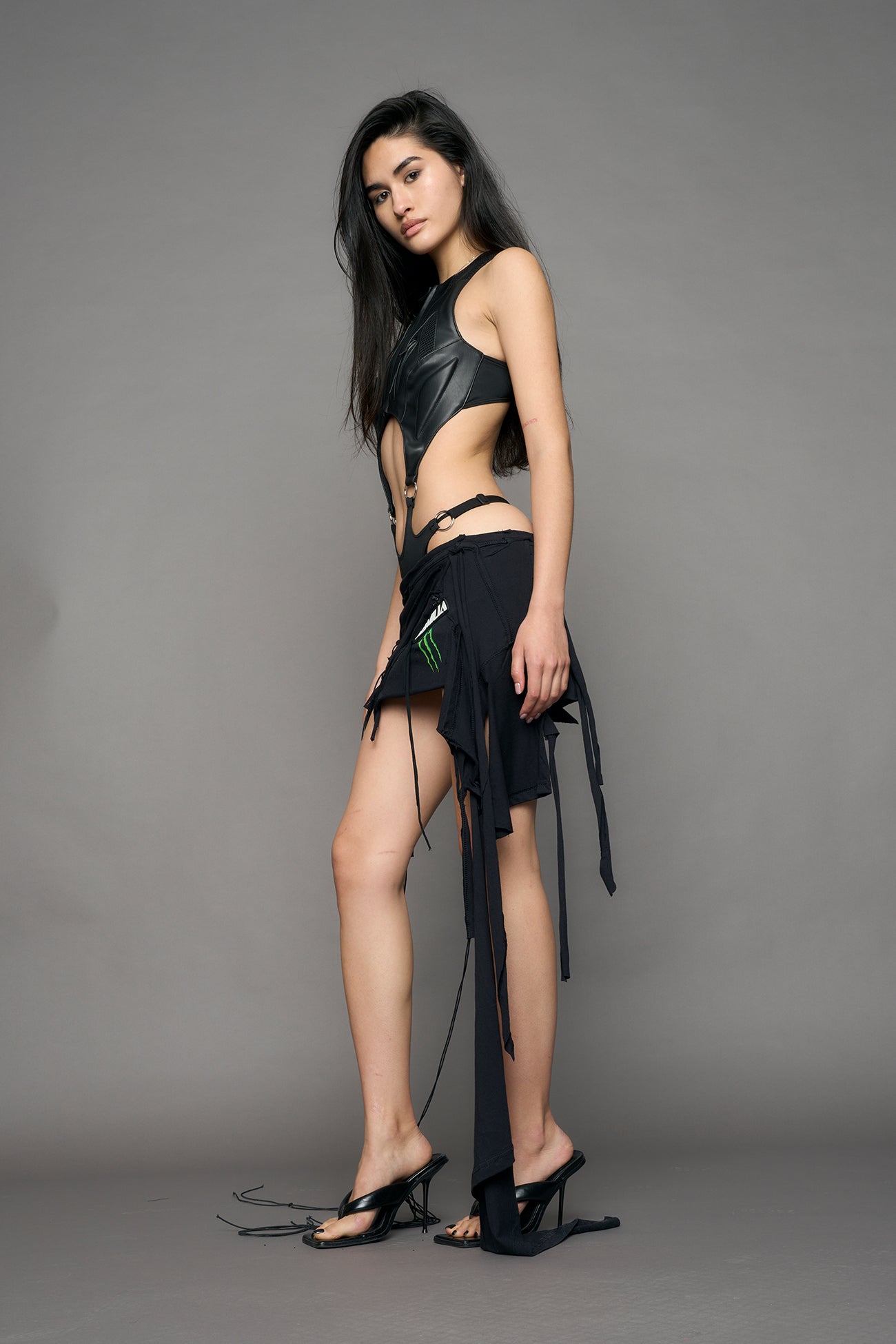model wearing black pu leather body with flat panty and moto style lines