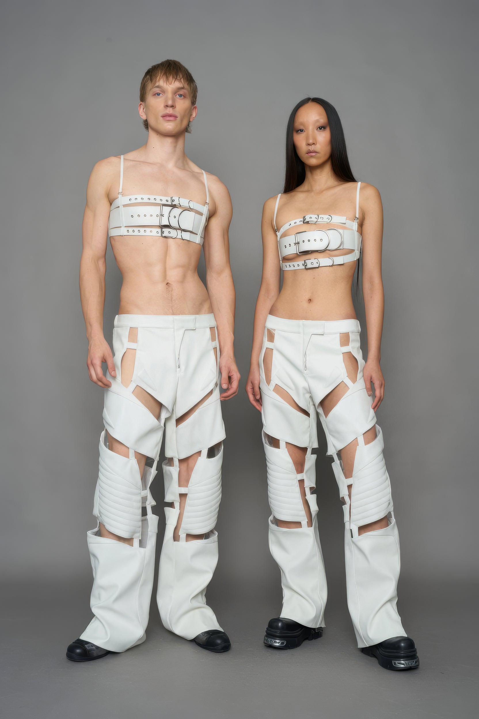models wearing white vegan leather pants with cut out details