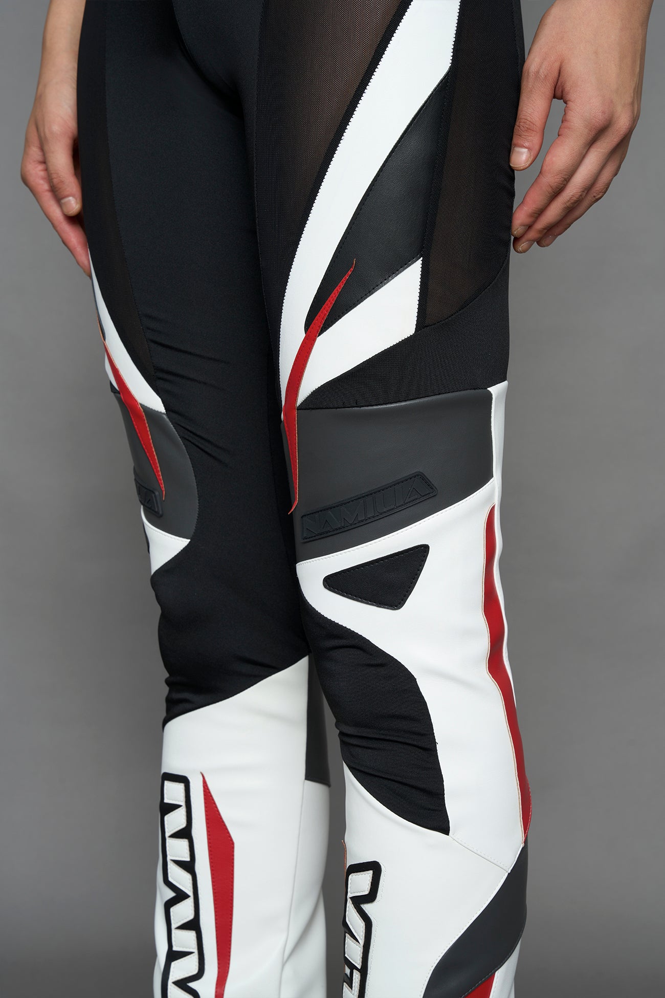 model wearing red black white moto inspired mesh pants with logo on the leg