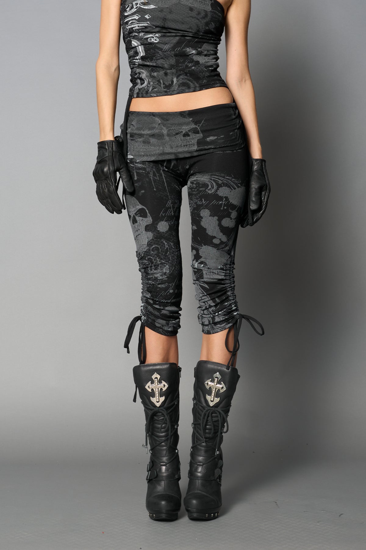 Model wearing black print capri pants with ruched sides and matching off-shoulder crop top