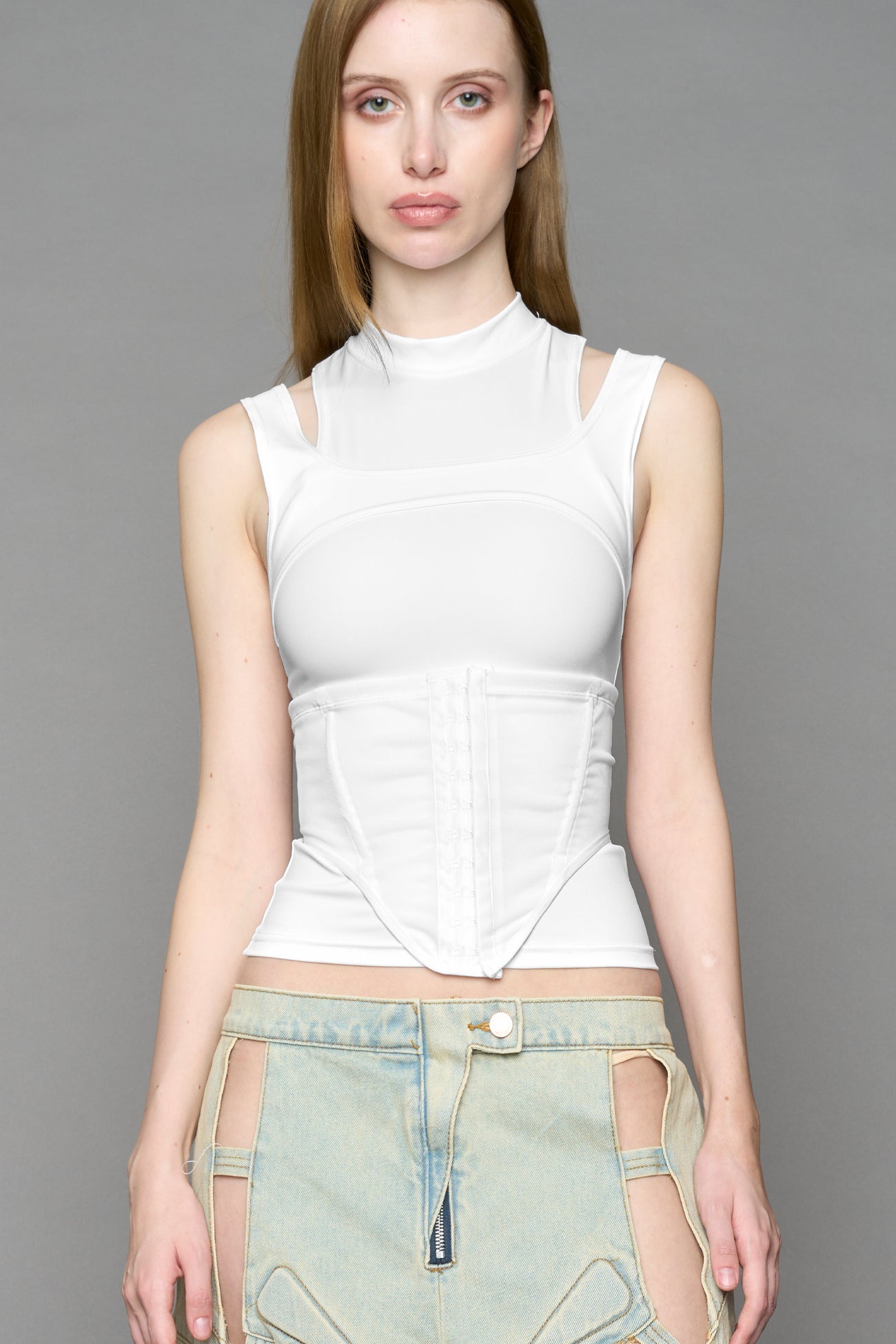 white contour top by NAMILIA featuring a sculpted fit, corset-style waist with hook-and-eye closure, and high neckline. Statement shaping top.