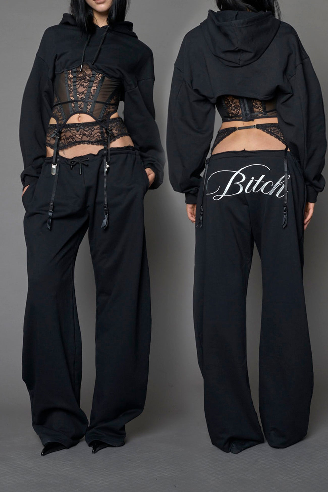 model wearing a black low waist jogger with a lace suspender belt and statement embroidery