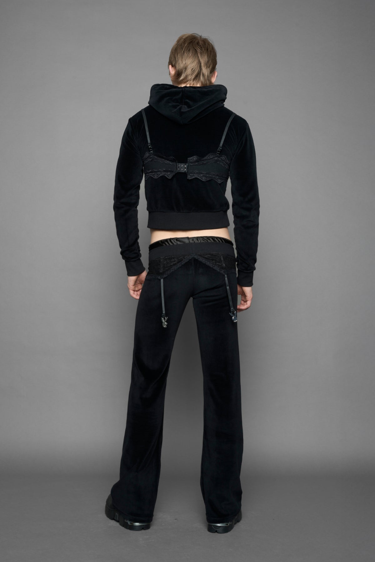 model is wearing a black velvet cropped zip-up hoodie with a black lace bralette and a Playboy branded key formed Zipper Pull