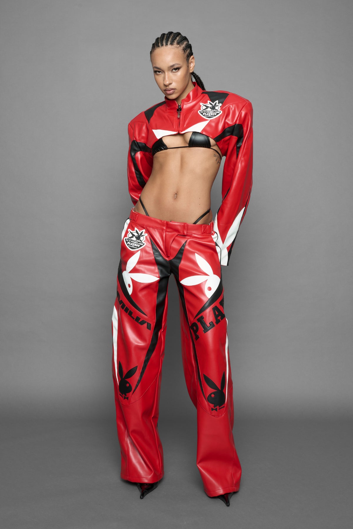 model is wearing red PU Leather pants with bold white Playboy bunny logos and white 'Namilia' Embroidery and rubber tag.