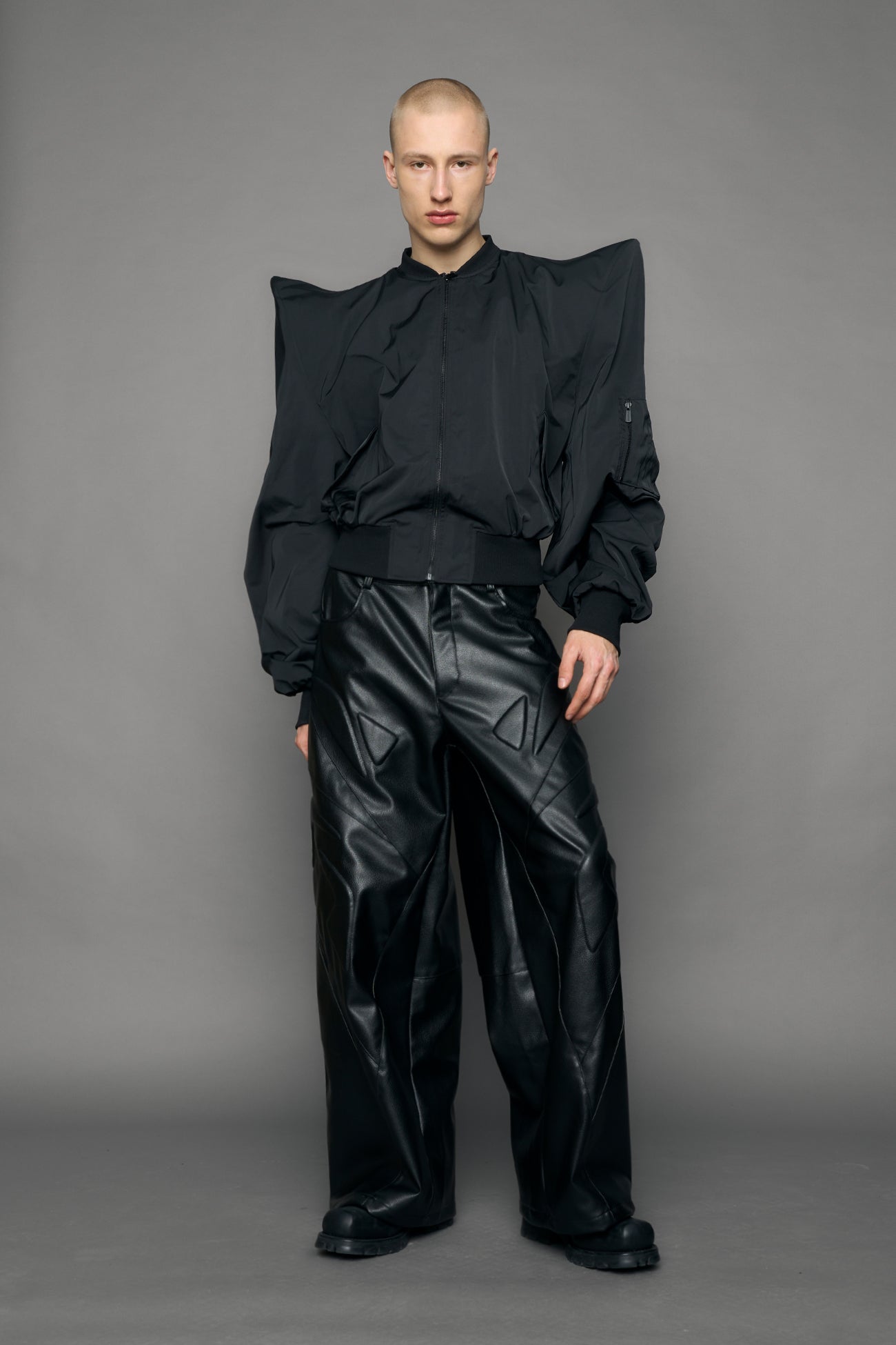 model wearing black bomber jacket with sharp shoulder design