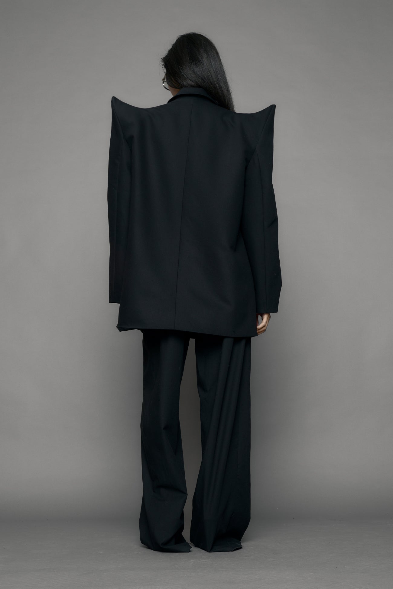 model wearing black blazer with sharp shoulder design