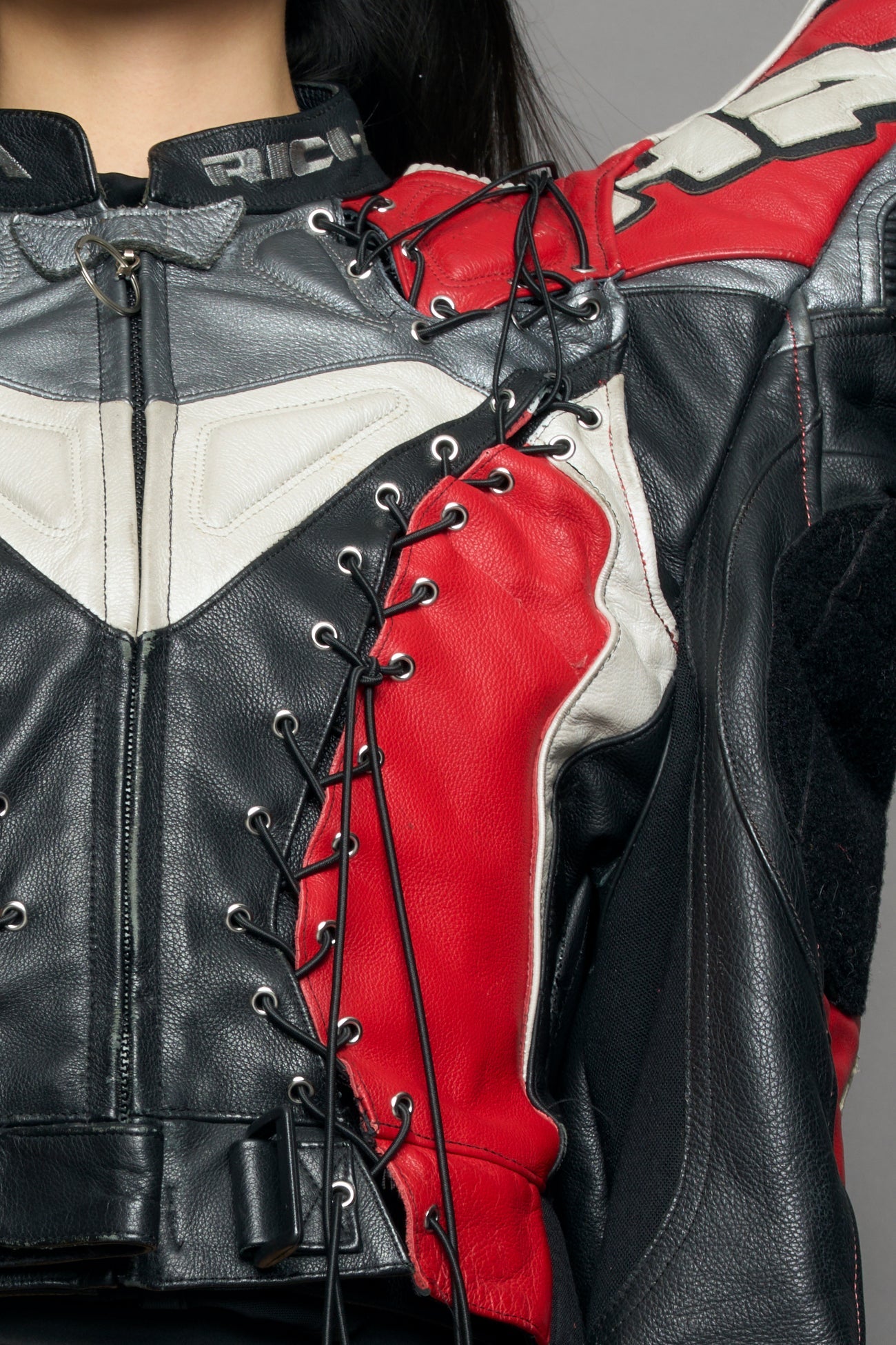 model wearing a motocross jacket with red and black accents on a gray background