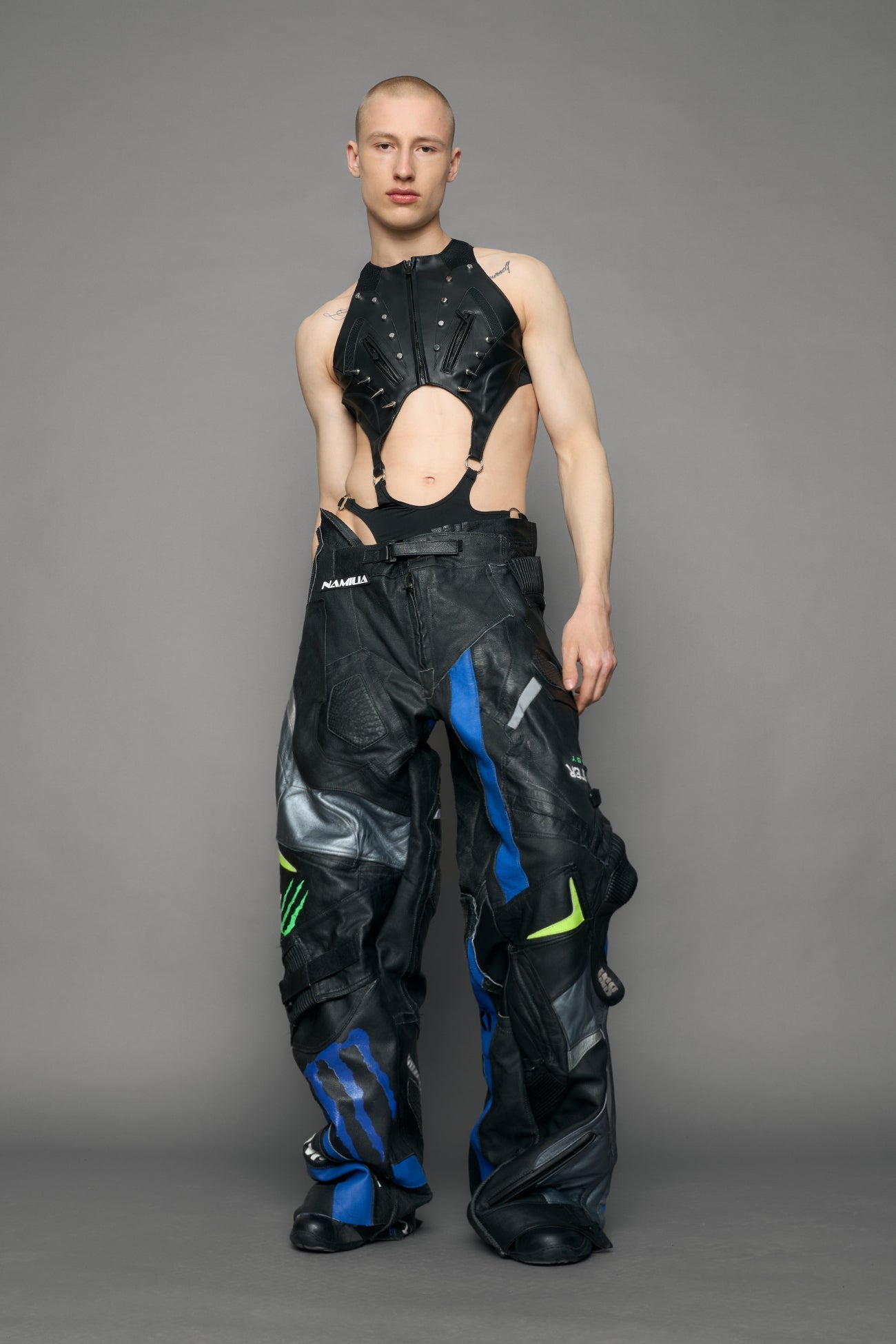 Person wearing a black bodysuit with cut-out design on a gray background