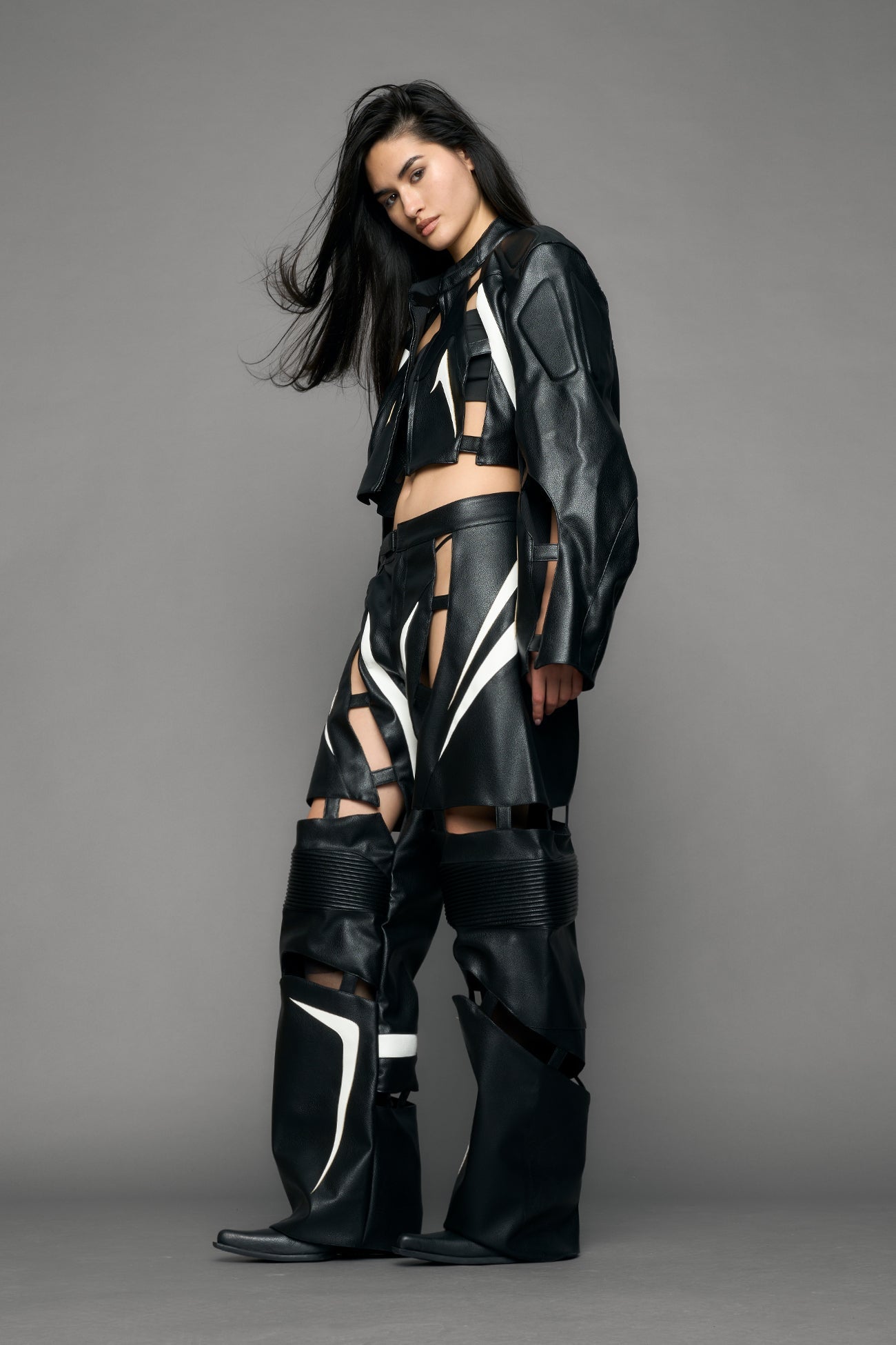 model wearing black and white pu leather pants with cut out details