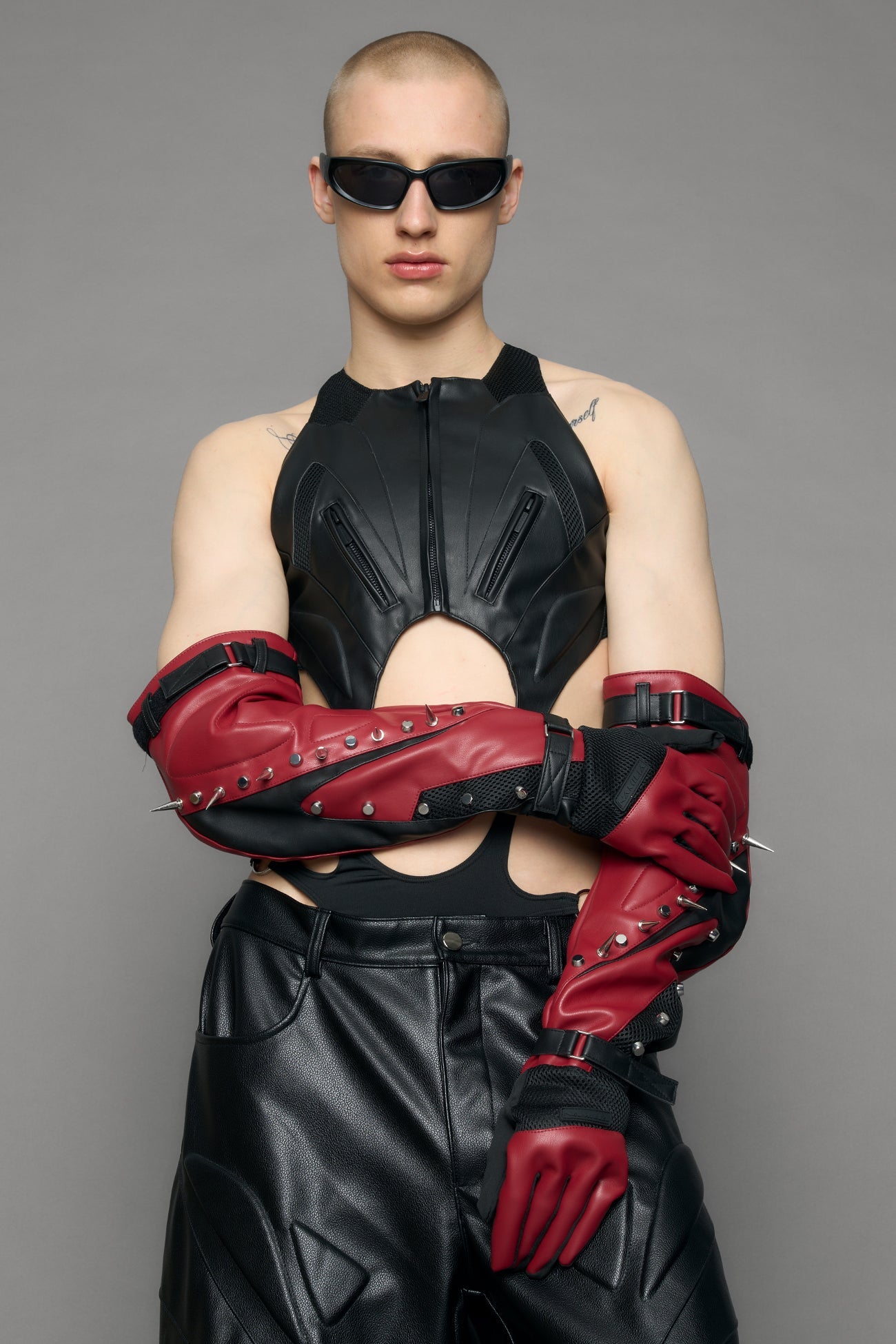 Model wearing a red studded leather gloves with silver and black details