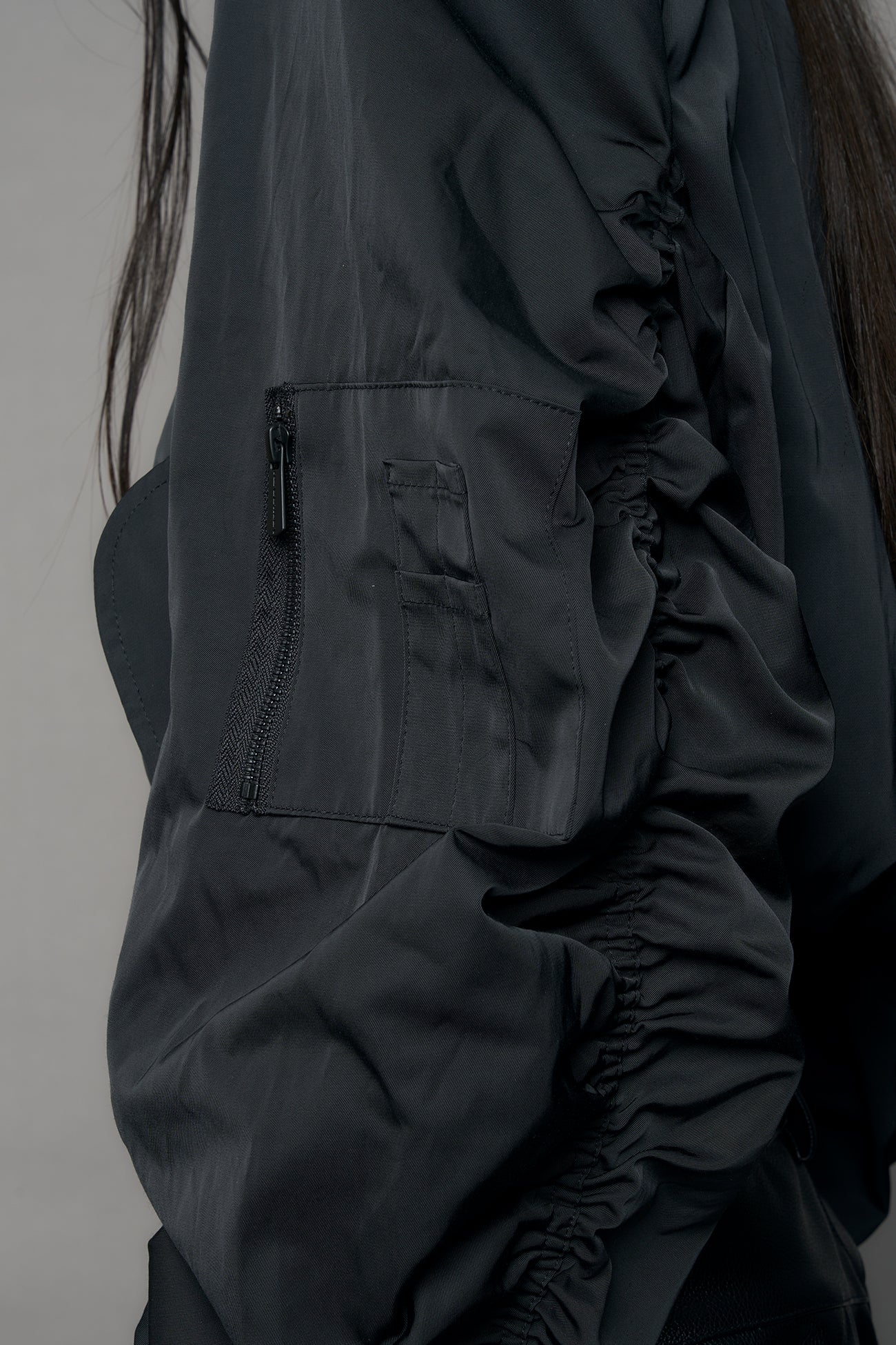 model wearing black bomber jacket with sharp shoulder design