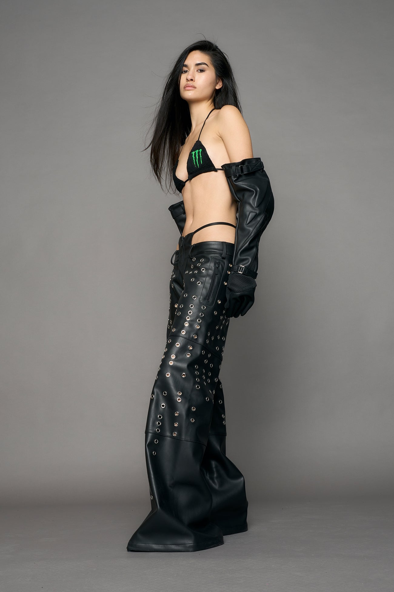 model wearing black pu leather pants with eyelet details