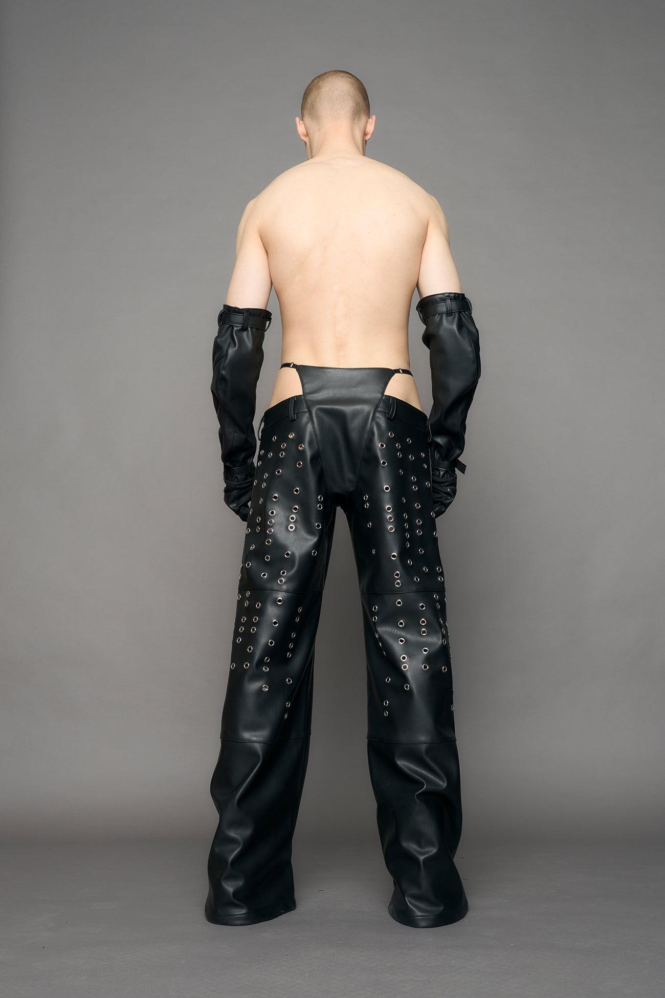 model wearing black pu leather pants with eyelet details