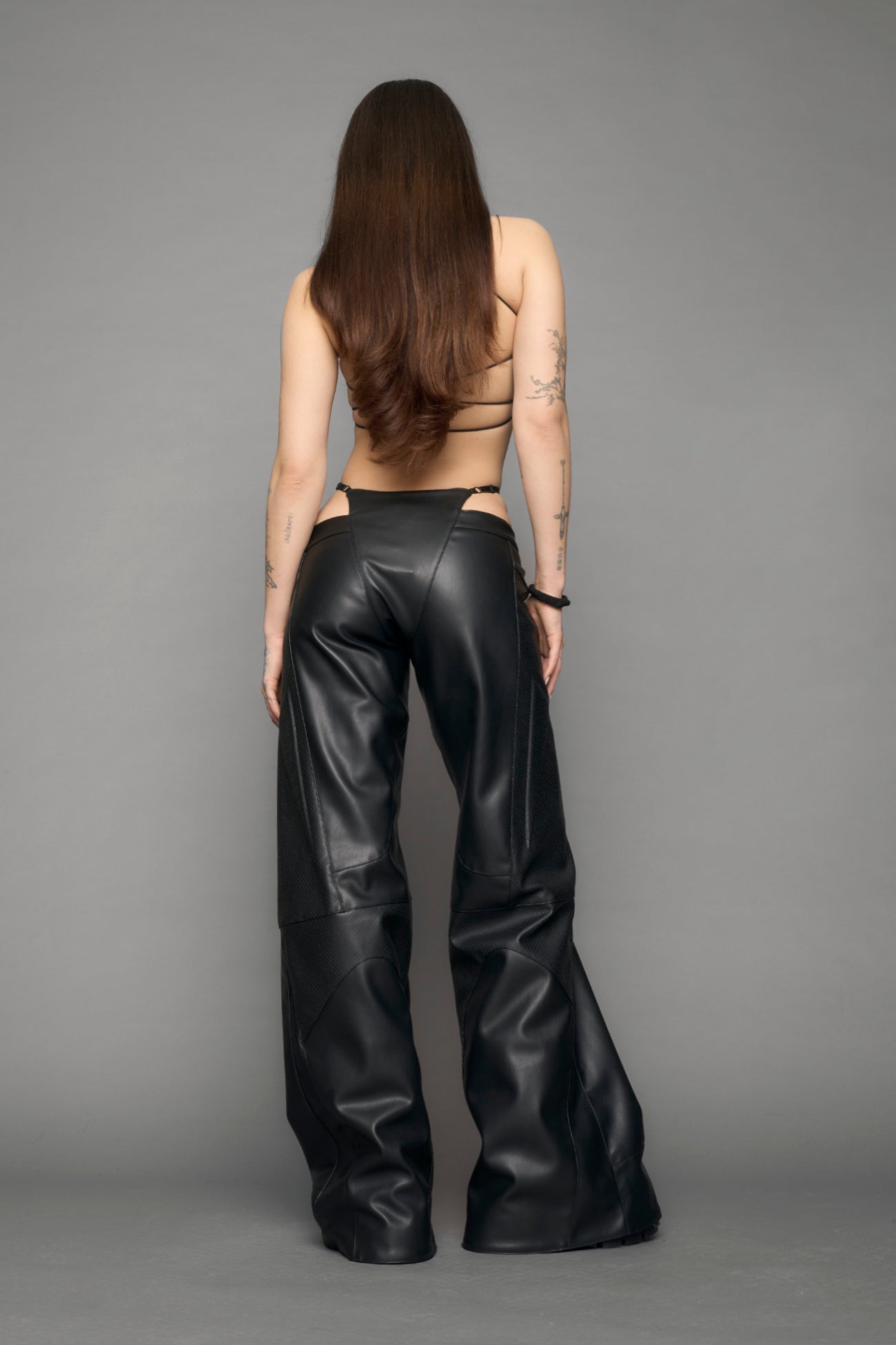 model wearing black vegan leather thong pants