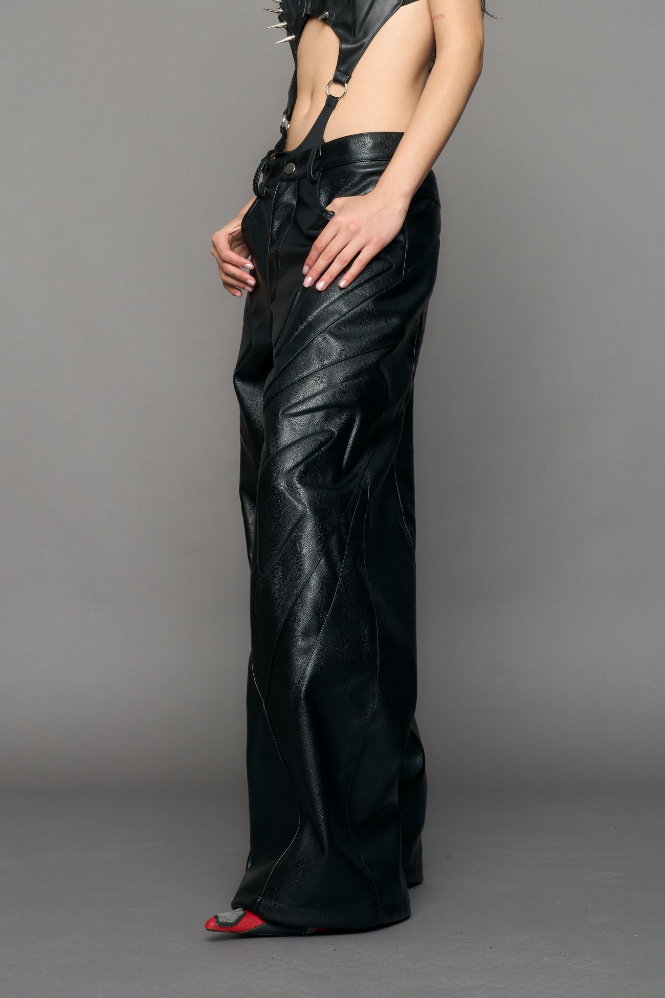 model wearing black oversize pu leather pants with moto style highlights