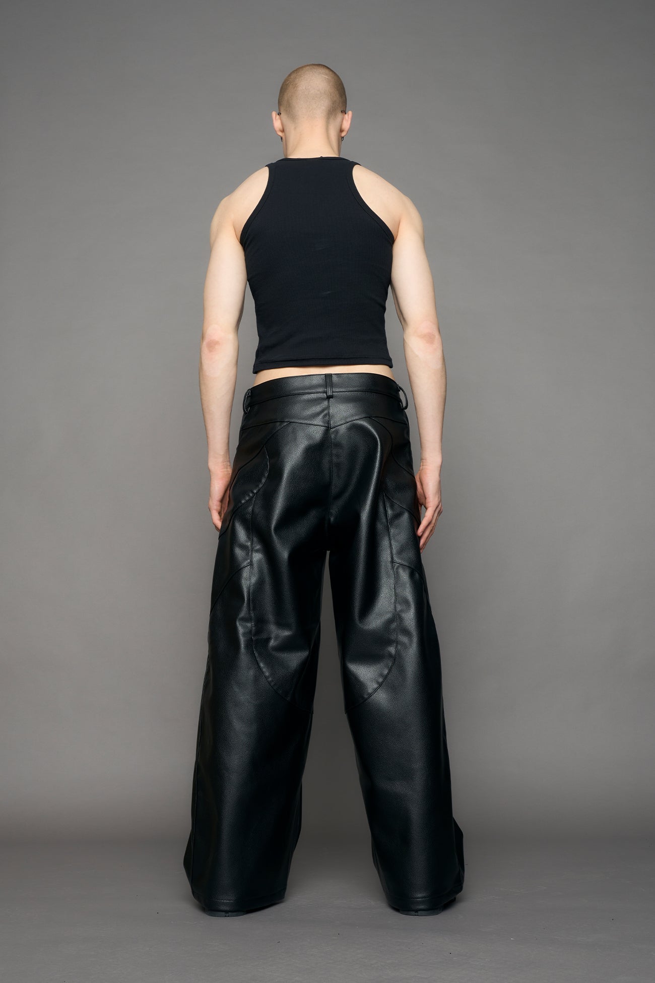 model wearing black oversize pu leather pants with moto style highlights