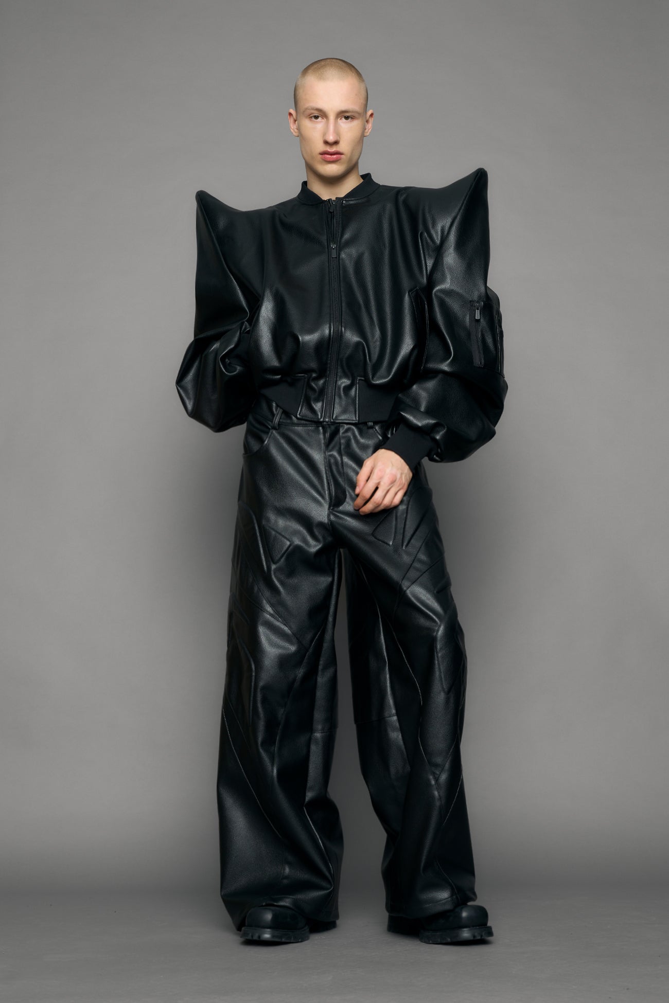 model wearing black pu leather bomber jacket with sharp shoulder design