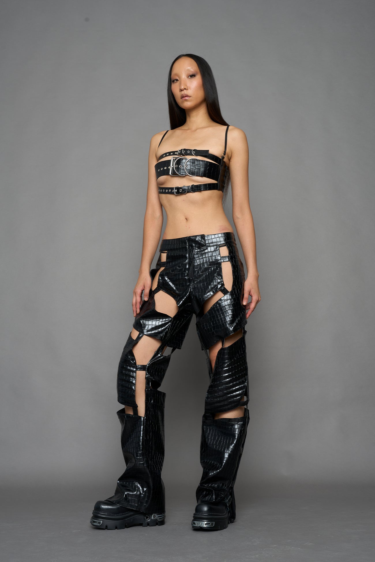 model wearing black croc vegan leather pants with cut out details