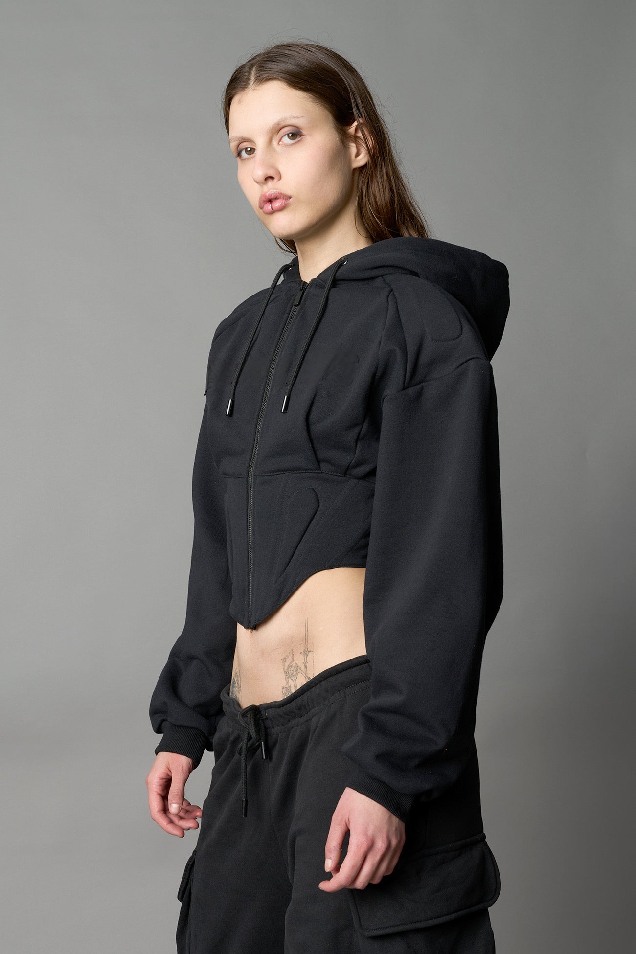 model wears black oversize hoodie with integrated corset