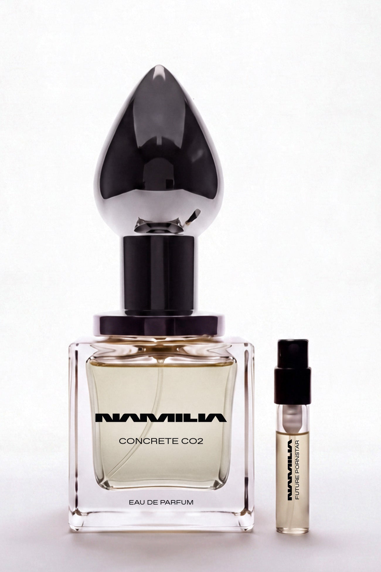 A bottle of Namilia Concrete CO2 Eau de Parfum with a large reflective black plug-shaped cap
