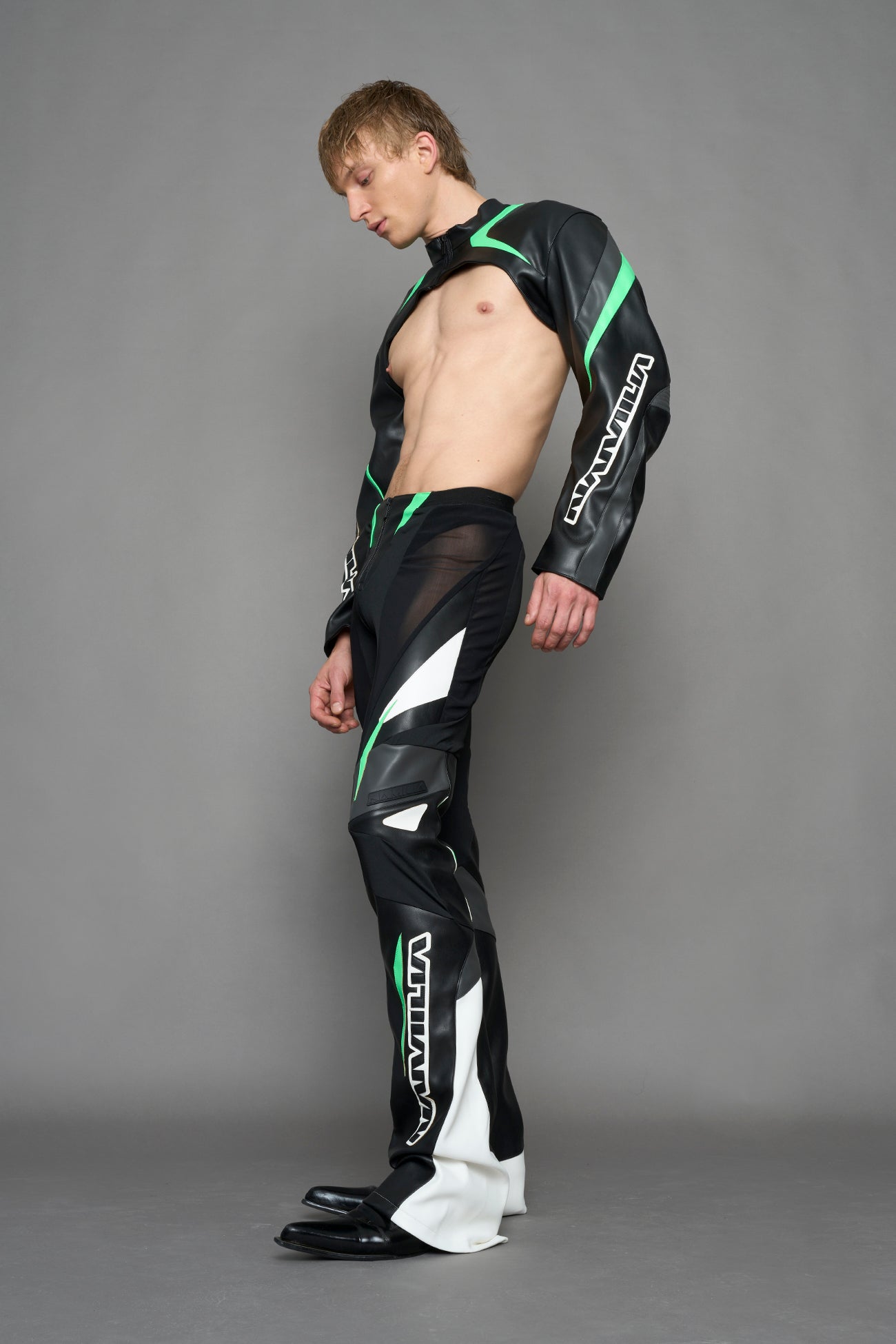 model wearing black white and green cropped jacket with logo on the arm