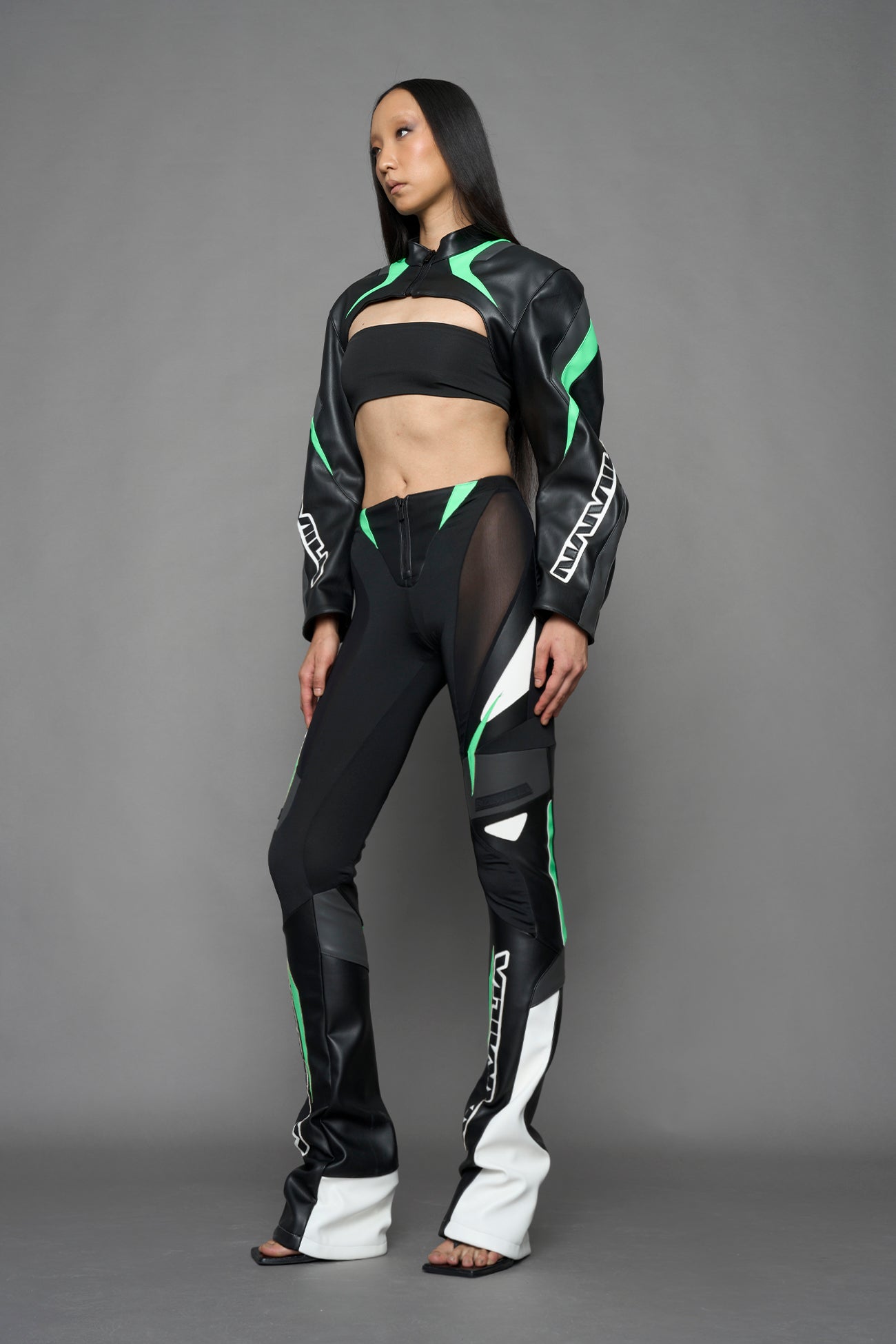 model wearing black white green moto inspired mesh pants with logo on the leg