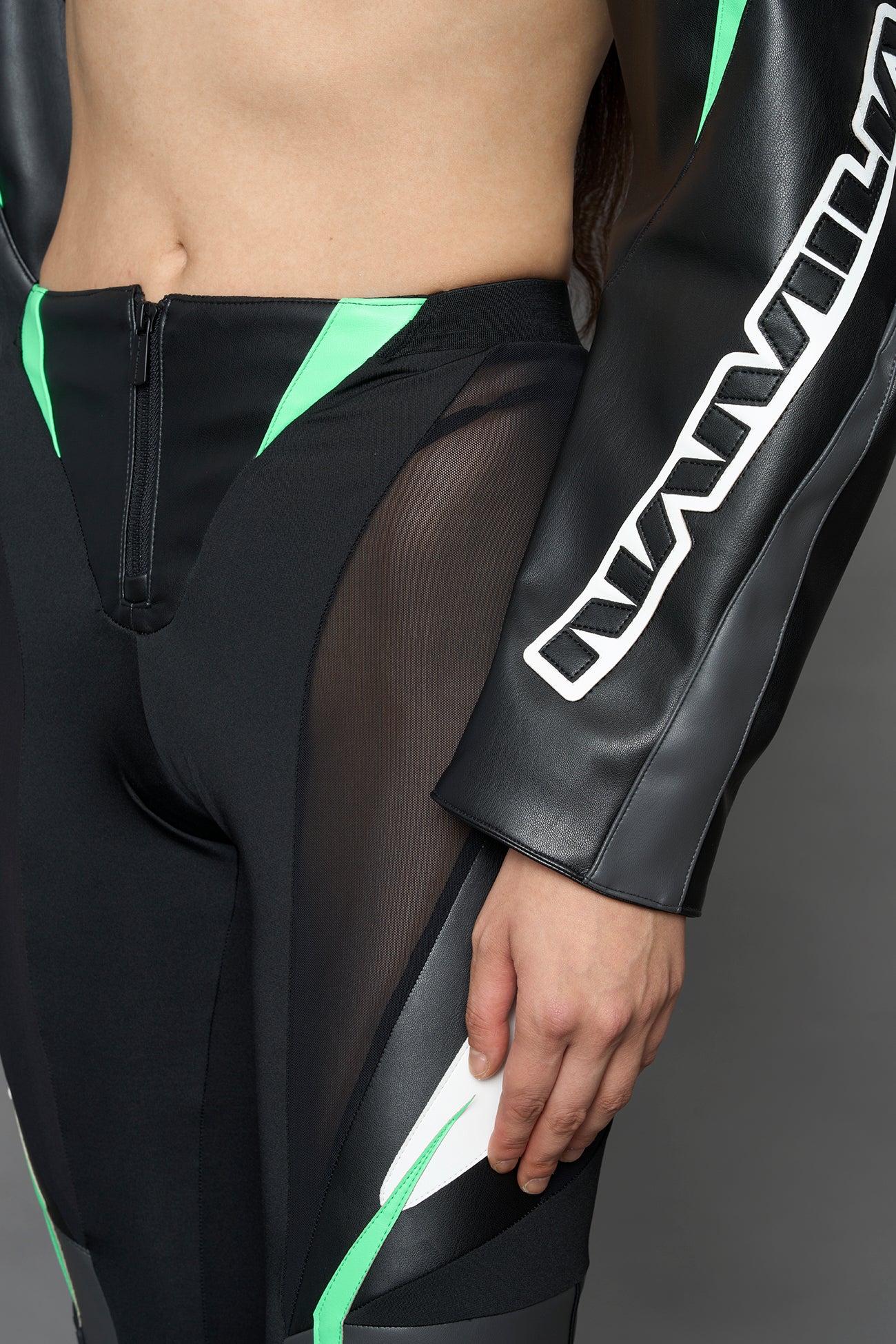 model wearing black white green moto inspired mesh pants with logo on the leg