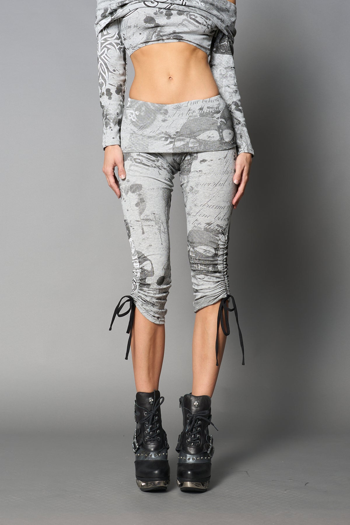 Model wearing grey print capri pants with ruched sides and matching off-shoulder crop top