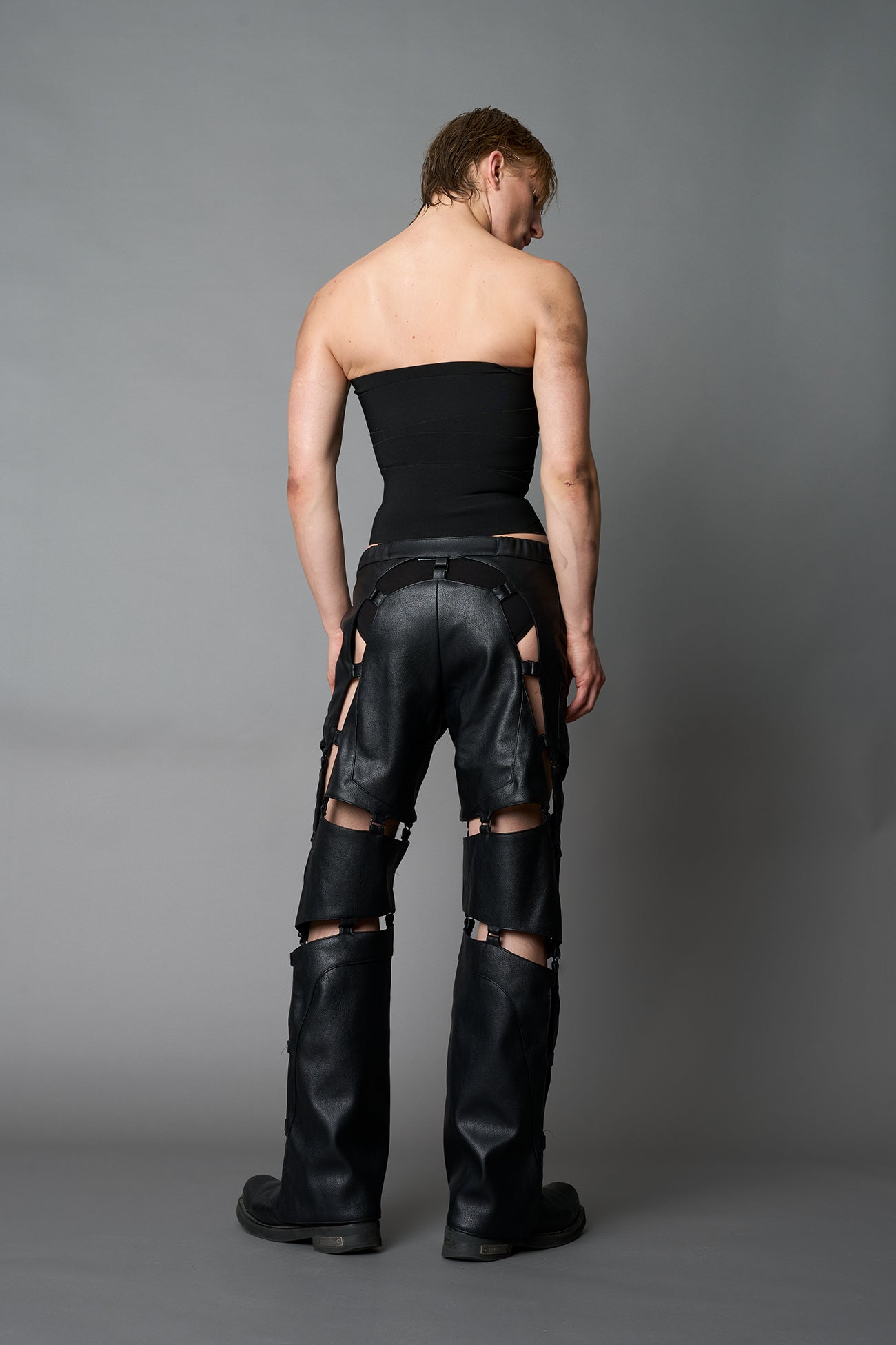 Model wearing black strapless bandage crop top with structured compression fit, edgy Y2K streetwear outfit by Namilia.