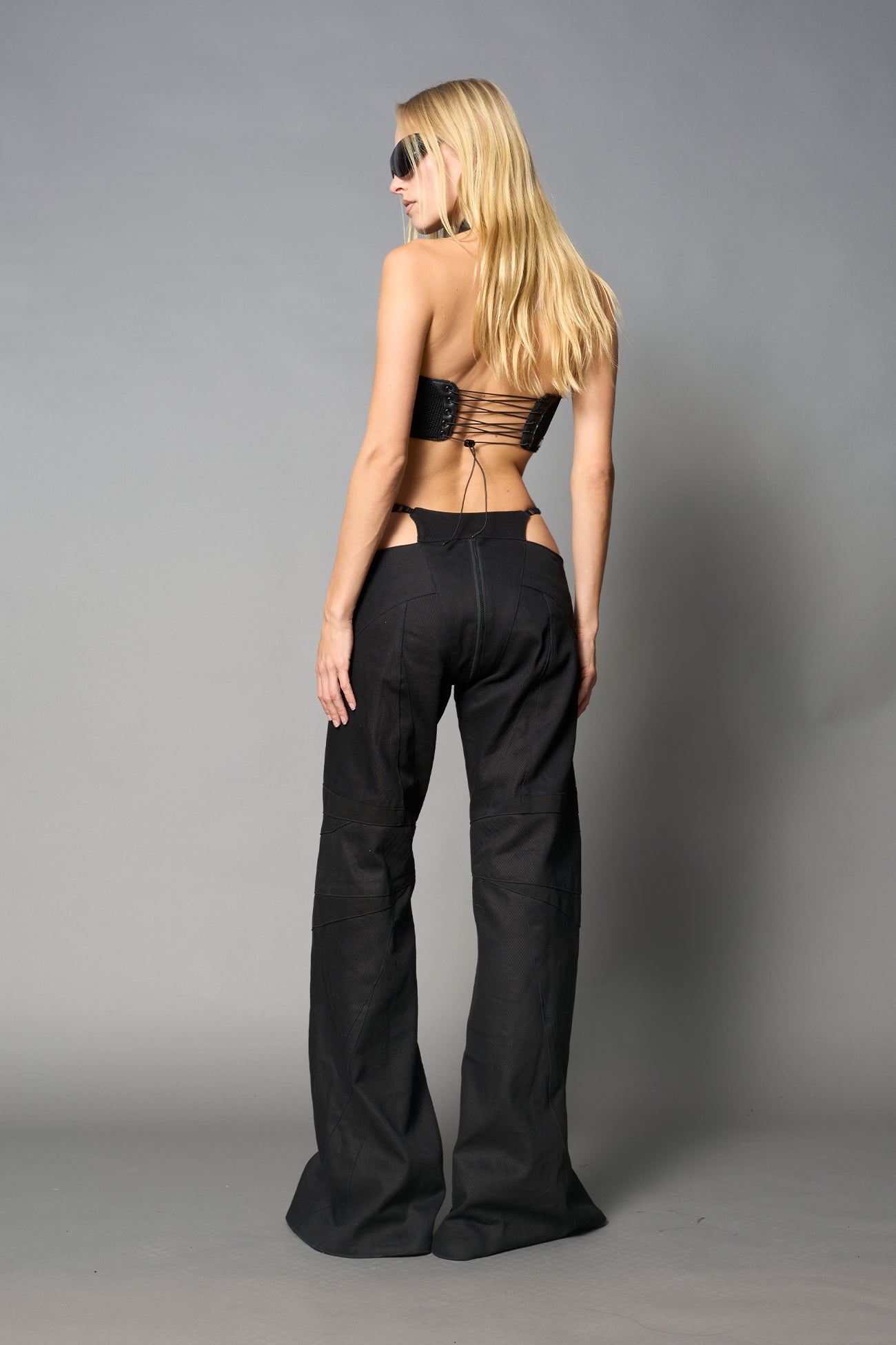 Black vegan leather neckholder crop top with lace-up front, high neck collar, and mesh panel detailing – edgy moto-inspired top for clubwear or streetwear.

