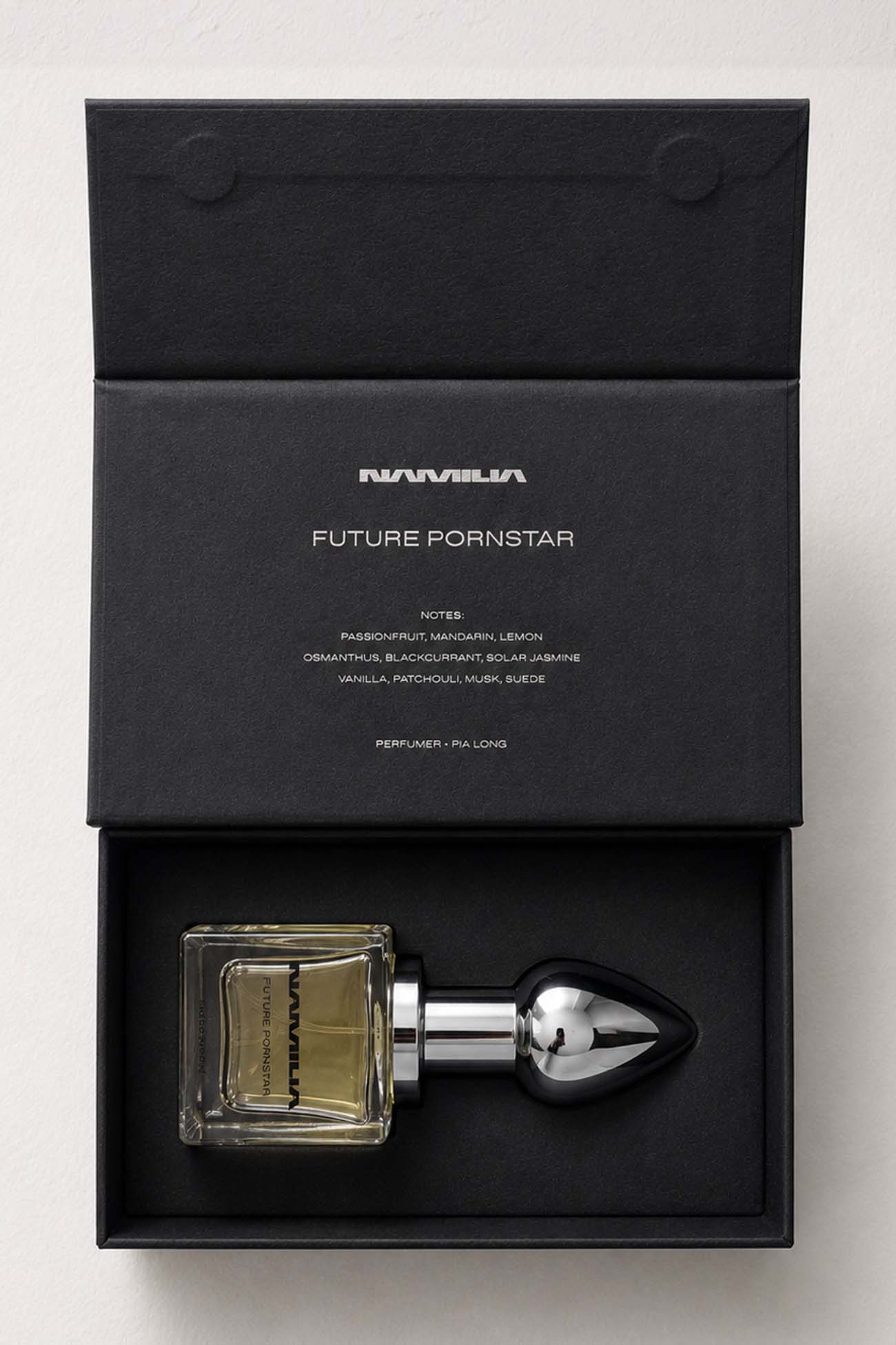 A bottle of Namila  Eau de Parfum with a large reflective plug-shaped cap