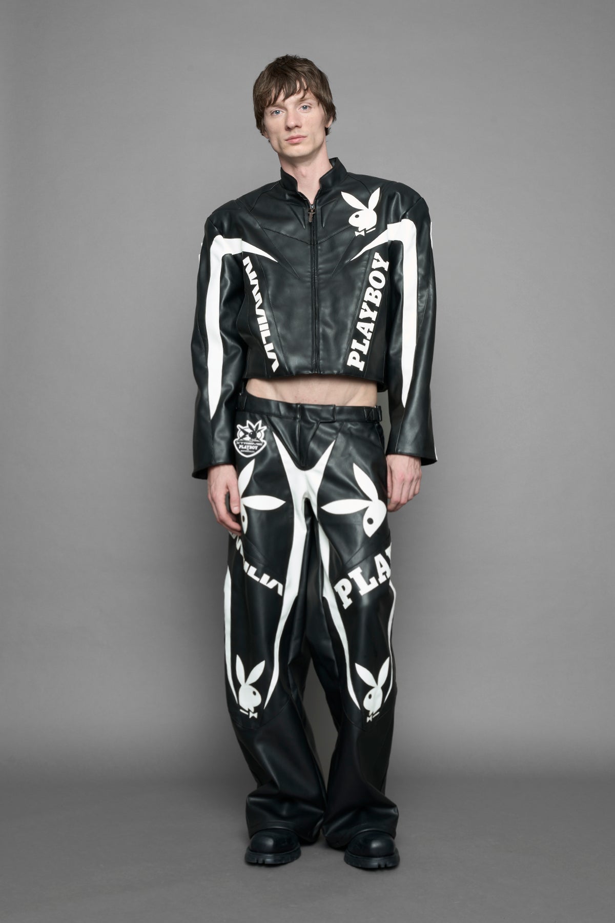 model is wearing black PU Leather pants with bold white Playboy bunny logos and white 'Namilia' Embroidery.