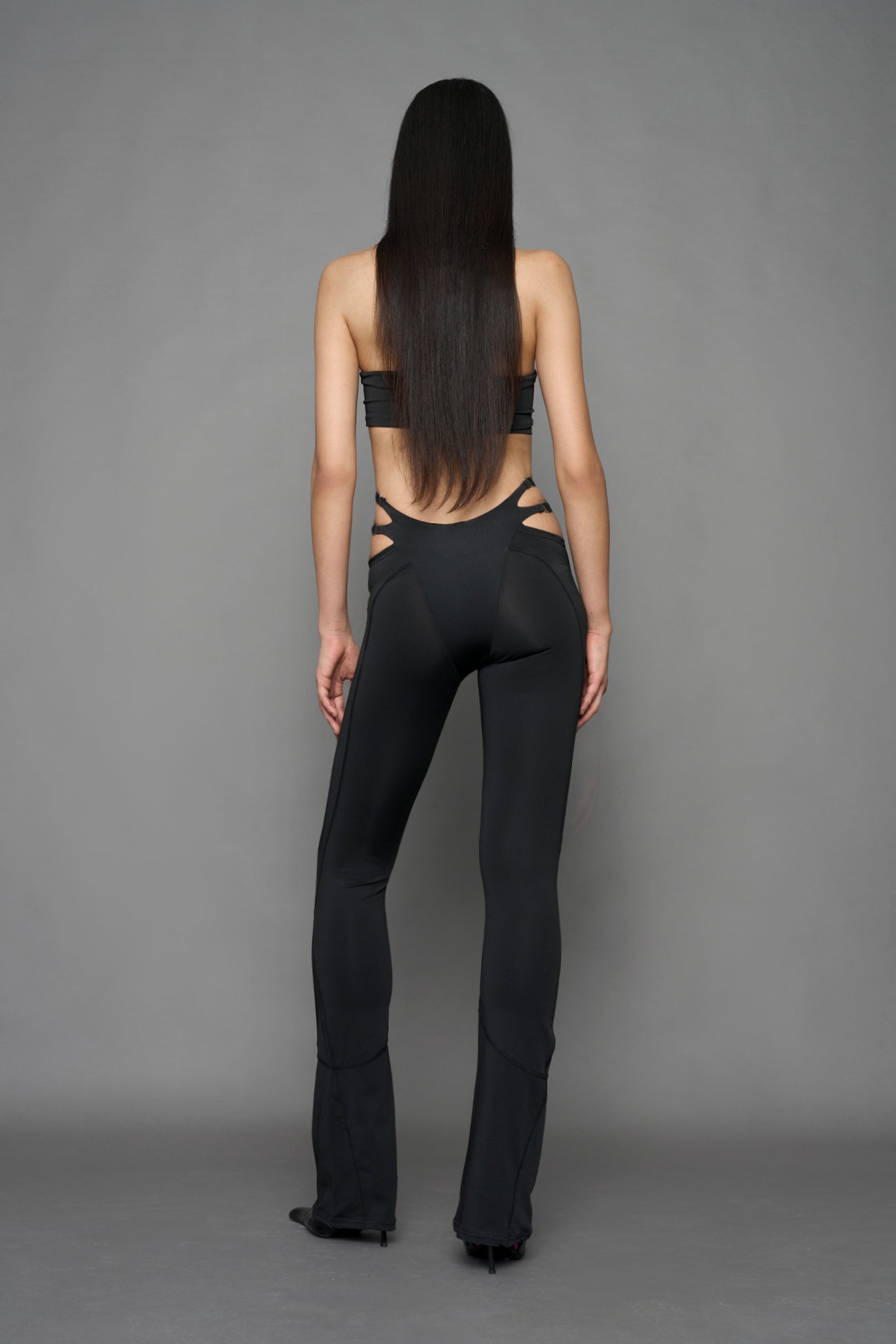 model wearing black tight leggings with hip cut outs