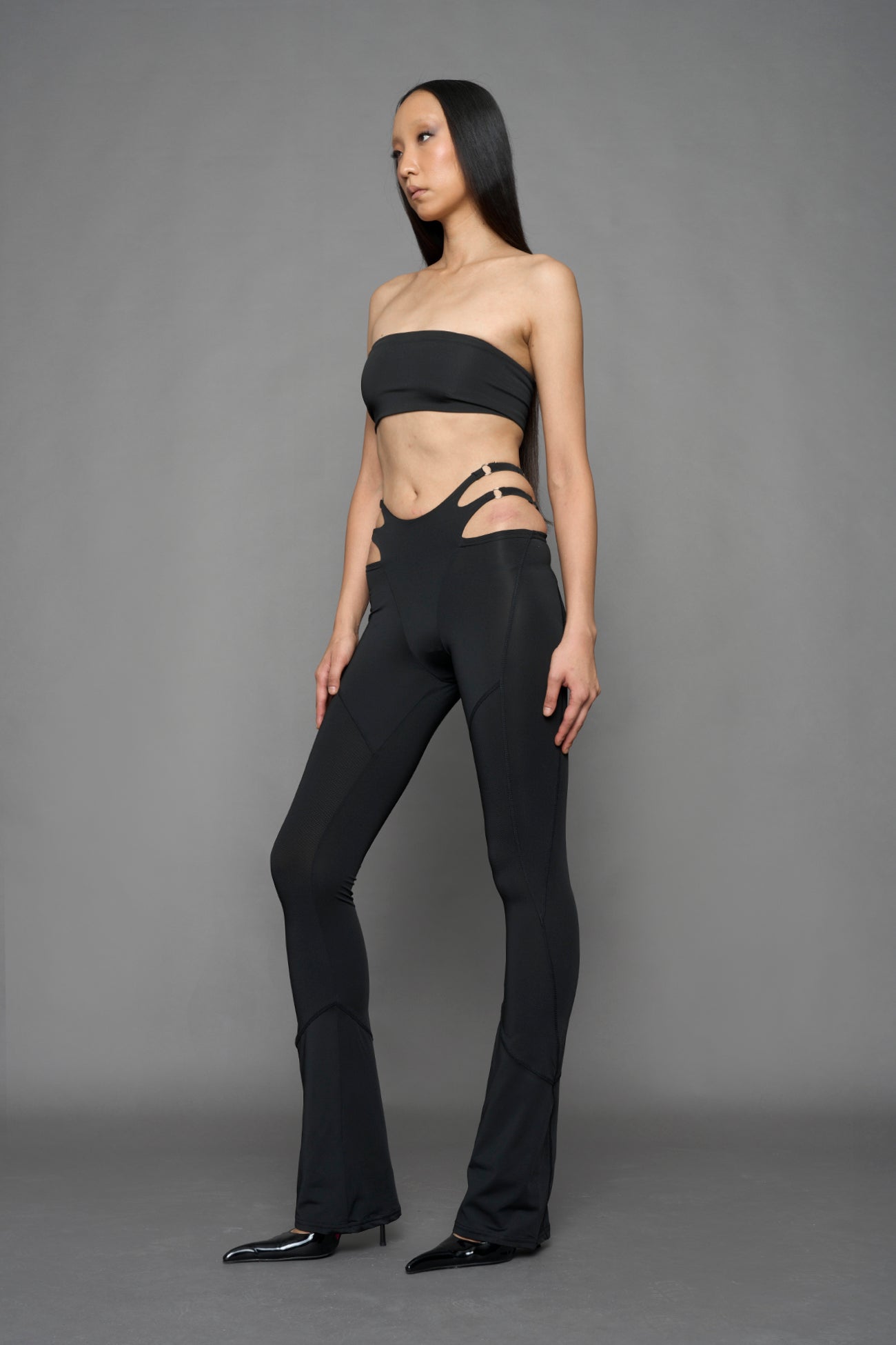 model wearing black tight leggings with hip cut outs